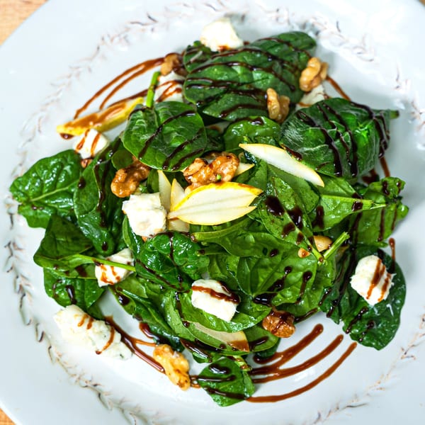 Edoardo's Trattoria's spinach salad with walnuts, pear slices, cheese, and balsamic glaze.